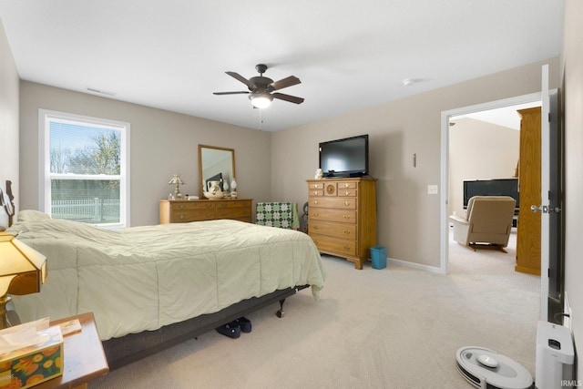 bedroom with ceiling fan, light colored carpet, baseboards, and visible vents