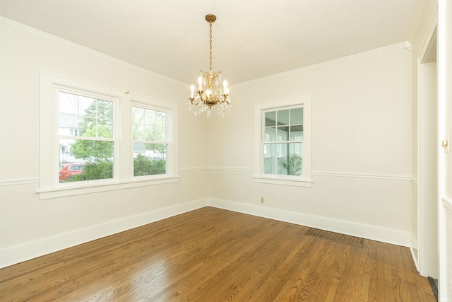 unfurnished room with crown molding, baseboards, an inviting chandelier, and dark wood finished floors