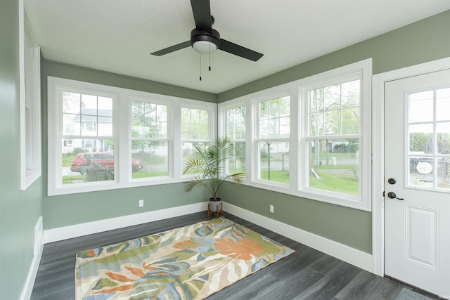 sunroom featuring baseboards and wood finished floors