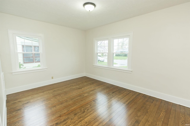 empty room featuring baseboards and dark wood-style flooring