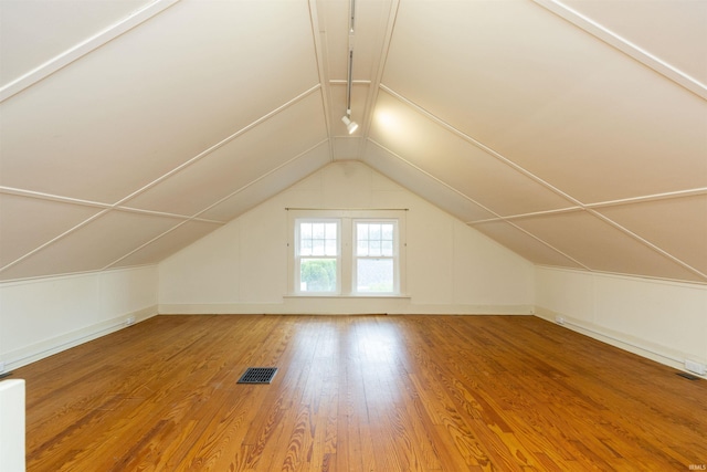 bonus room with visible vents, baseboards, wood finished floors, and vaulted ceiling