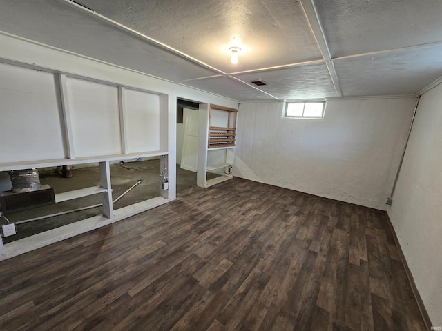basement featuring visible vents and dark wood-style floors