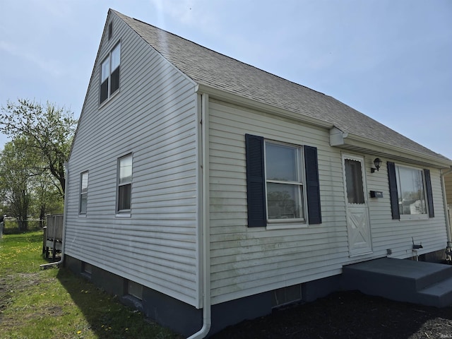 view of side of property featuring a shingled roof