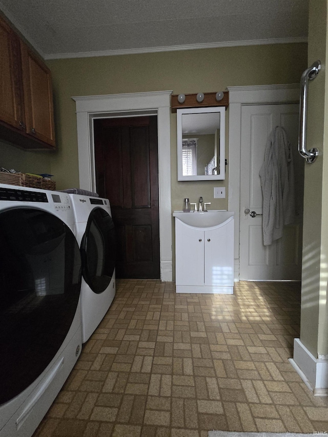 laundry area with washing machine and clothes dryer, cabinet space, a sink, brick patterned floor, and ornamental molding