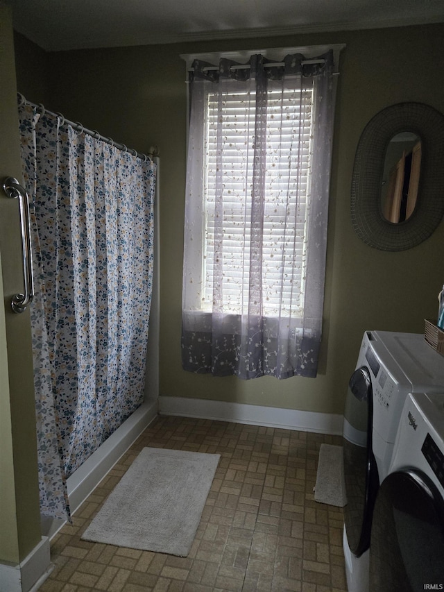 full bath featuring washing machine and clothes dryer, baseboards, brick patterned floor, and curtained shower