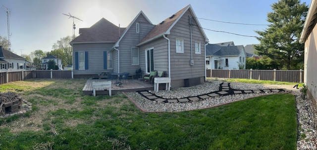 back of house with a fenced backyard, a yard, and a deck