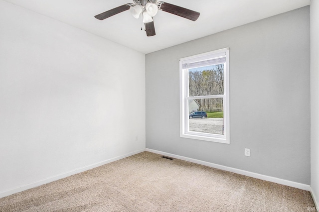 unfurnished room featuring baseboards, a ceiling fan, carpet flooring, and visible vents
