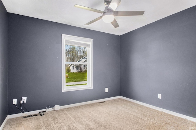 spare room featuring visible vents, a ceiling fan, baseboards, and carpet flooring