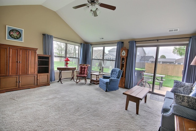 carpeted living room featuring ceiling fan, visible vents, and high vaulted ceiling