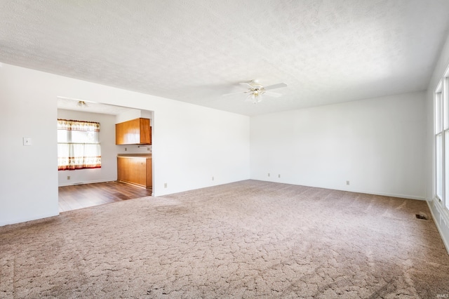 208 E Hickory Grove Rd, Hartford City, IN 47348 - unfurnished living room featuring ceiling fan, carpet, a textured ceiling, and visible vents