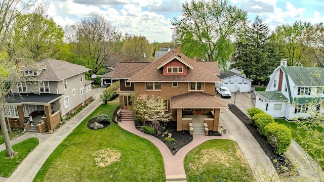view of front of home featuring a residential view, a garage, a front lawn, and brick siding