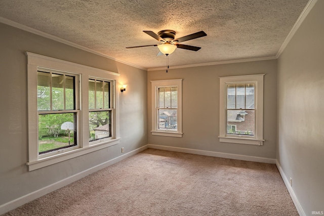 spare room with ceiling fan, a textured ceiling, light colored carpet, crown molding, and baseboards