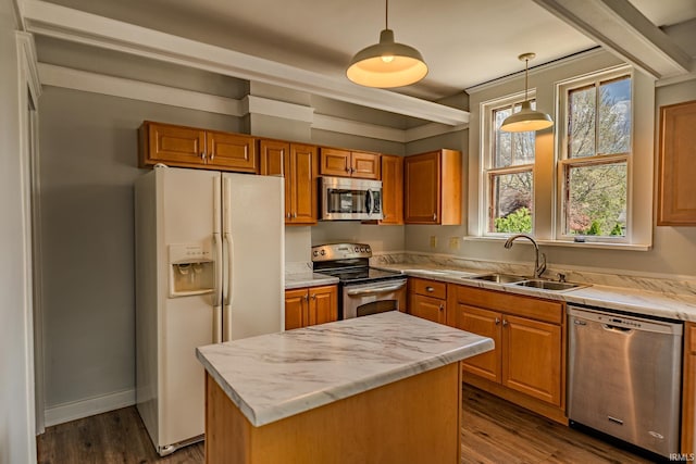 kitchen featuring a sink, appliances with stainless steel finishes, hanging light fixtures, and brown cabinetry