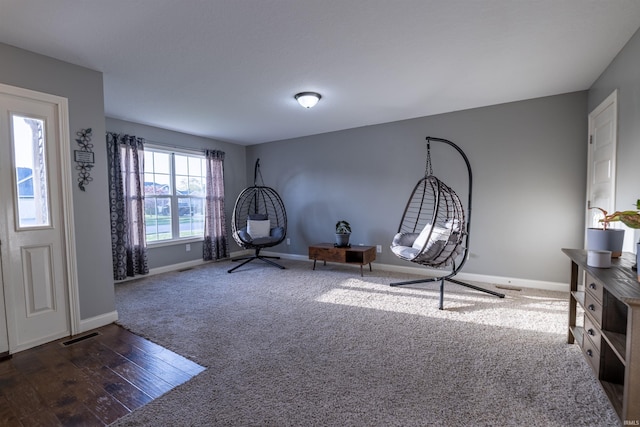interior space with baseboards, carpet flooring, wood finished floors, and visible vents