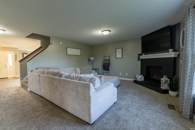 living room featuring visible vents, carpet flooring, stairway, and a large fireplace