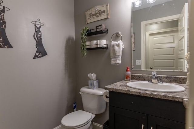 half bath with vanity, baseboards, and toilet