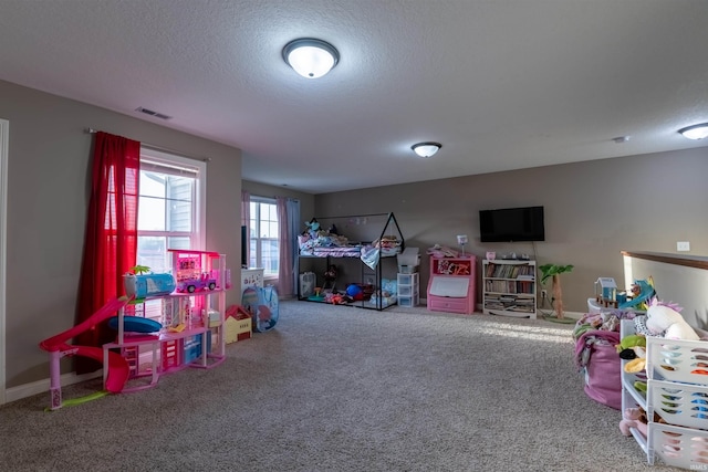 rec room featuring a textured ceiling, visible vents, and carpet