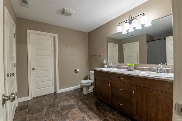 bathroom with baseboards, visible vents, and a sink