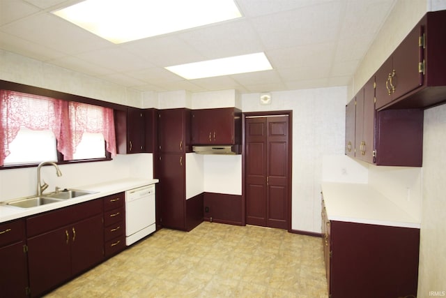 kitchen featuring light countertops, white dishwasher, a sink, and light floors