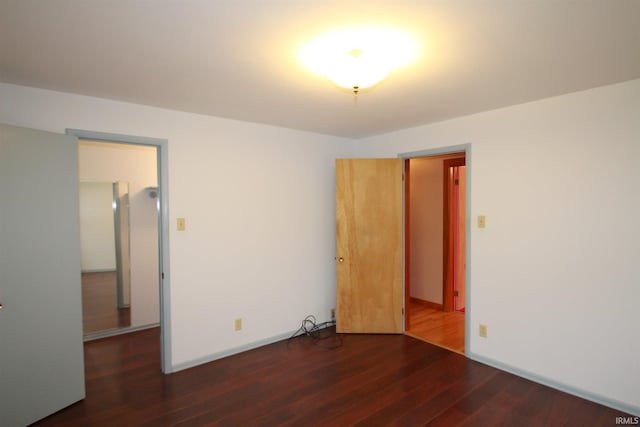 unfurnished room featuring baseboards and wood finished floors