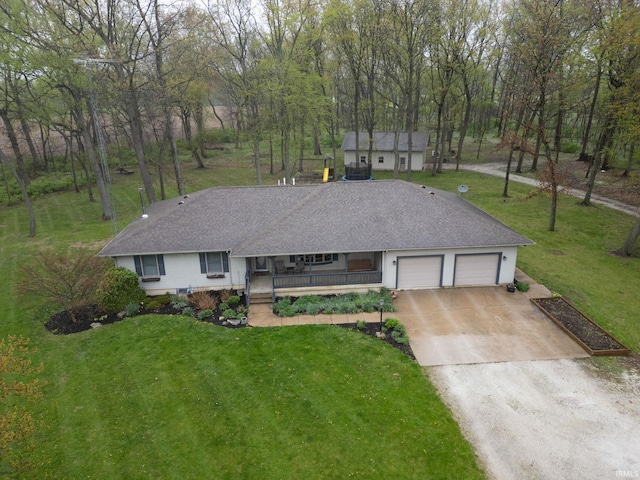 view of front of property with a porch, roof with shingles, a front yard, concrete driveway, and an attached garage