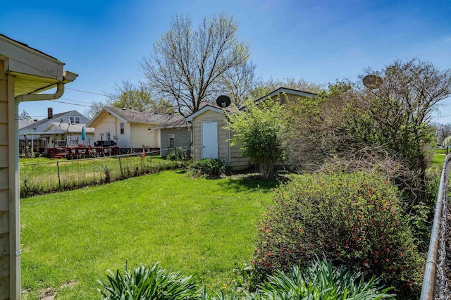 view of yard featuring fence, an outbuilding, and a shed