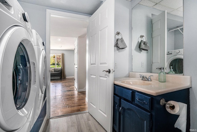 bathroom with washer / clothes dryer, wood finished floors, and vanity