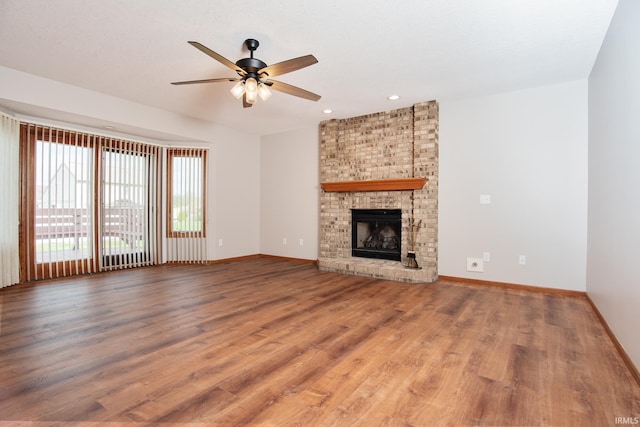 unfurnished living room with ceiling fan, a fireplace, wood finished floors, baseboards, and recessed lighting