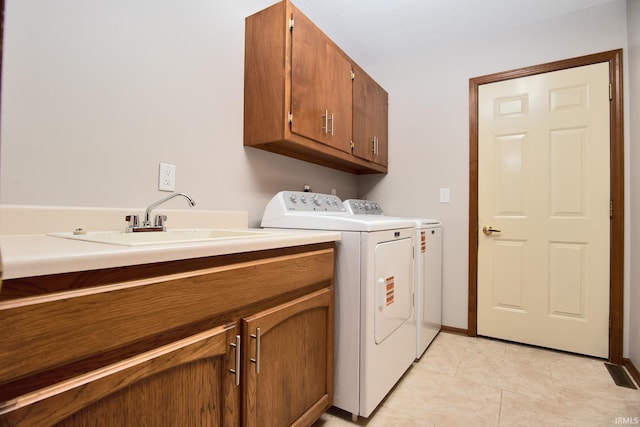 laundry area featuring cabinet space, light tile patterned flooring, a sink, and washer and dryer