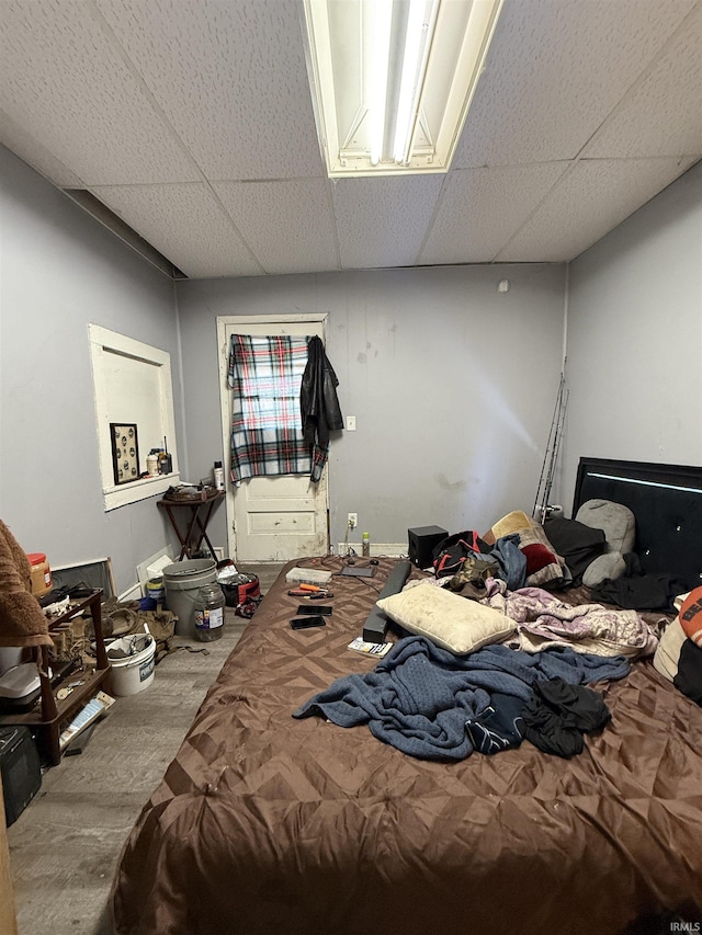 carpeted bedroom featuring a drop ceiling