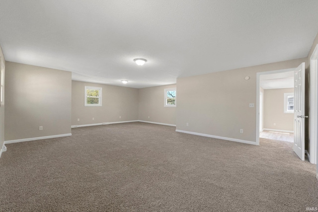 spare room featuring carpet floors and baseboards