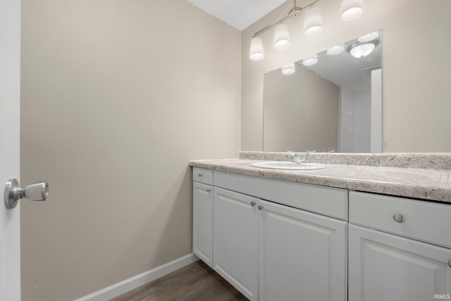 bathroom with vanity, baseboards, and wood finished floors