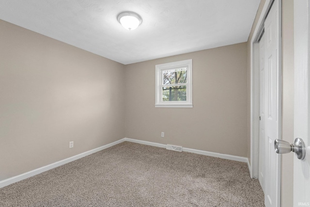 unfurnished bedroom with a closet, carpet, baseboards, and visible vents