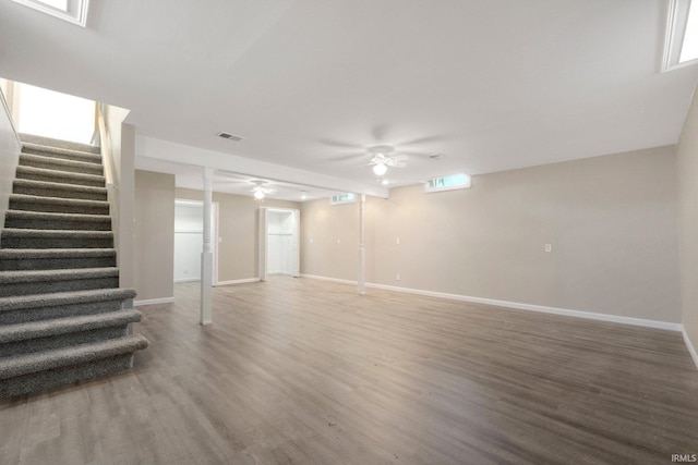 basement with ceiling fan, visible vents, wood finished floors, stairway, and baseboards