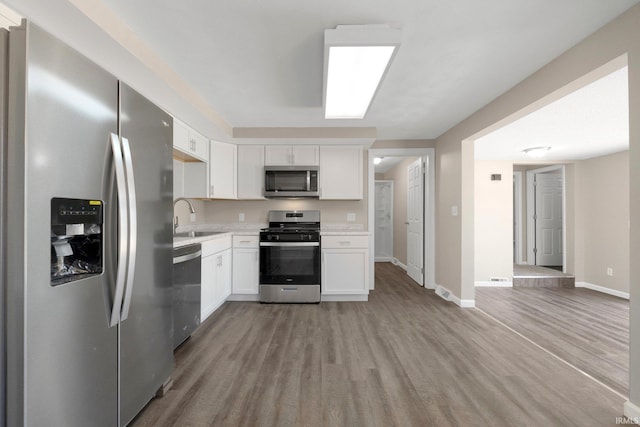 kitchen featuring light wood-style floors, a sink, light countertops, and stainless steel appliances