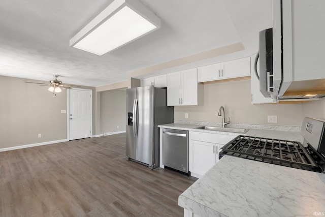 kitchen featuring ceiling fan, dark wood-type flooring, light countertops, a sink, and appliances with stainless steel finishes