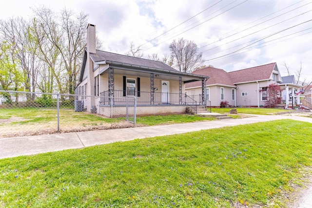 view of front of home featuring fence private yard, a chimney, a porch, and a front yard