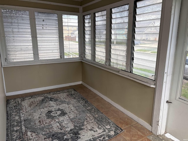 unfurnished sunroom featuring baseboards