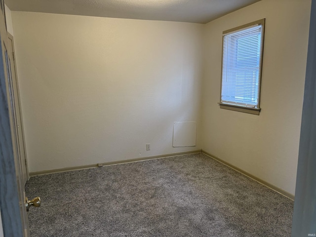 carpeted empty room with baseboards