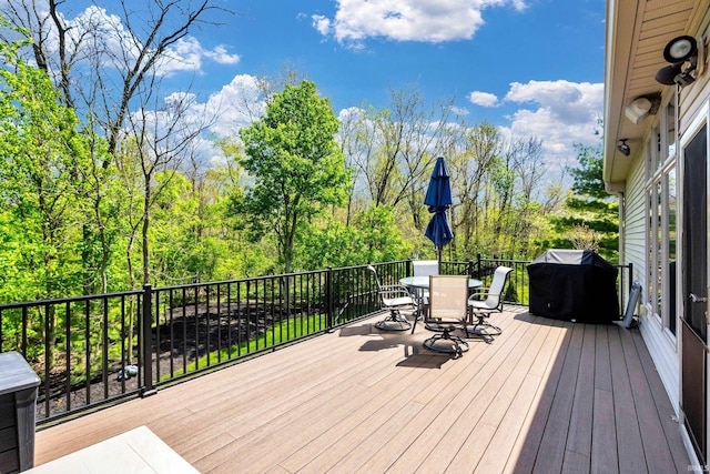 wooden terrace with outdoor dining area and area for grilling