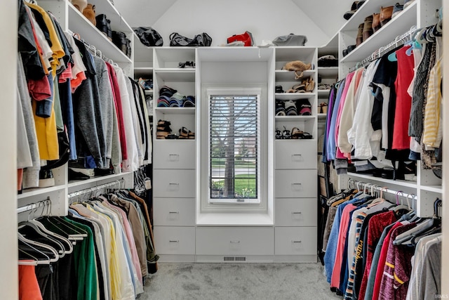 walk in closet with carpet floors, vaulted ceiling, and visible vents