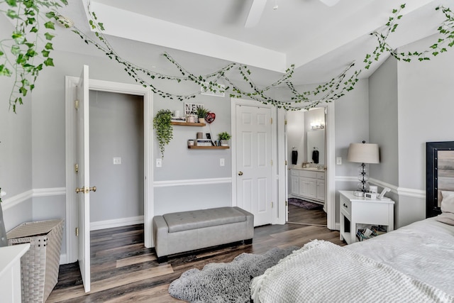 bedroom with baseboards, ceiling fan, wood finished floors, and connected bathroom