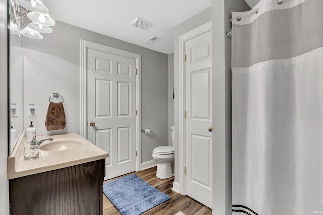 full bathroom featuring visible vents, wood finished floors, toilet, and vanity