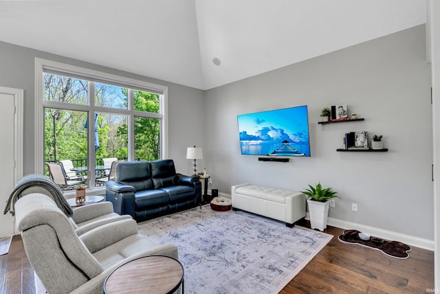 living area featuring baseboards, dark wood-style floors, and high vaulted ceiling