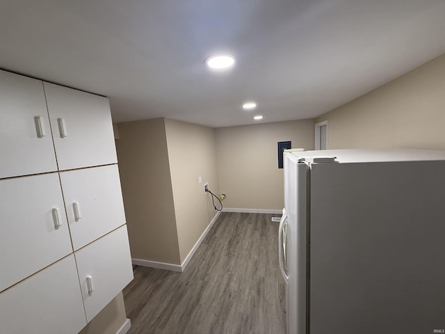 laundry room with baseboards, recessed lighting, and wood finished floors