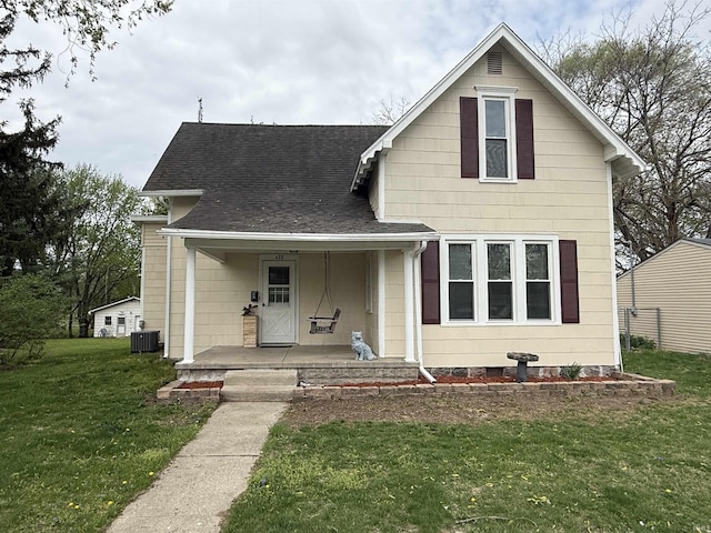 traditional-style house with a porch, a shingled roof, a front lawn, and cooling unit