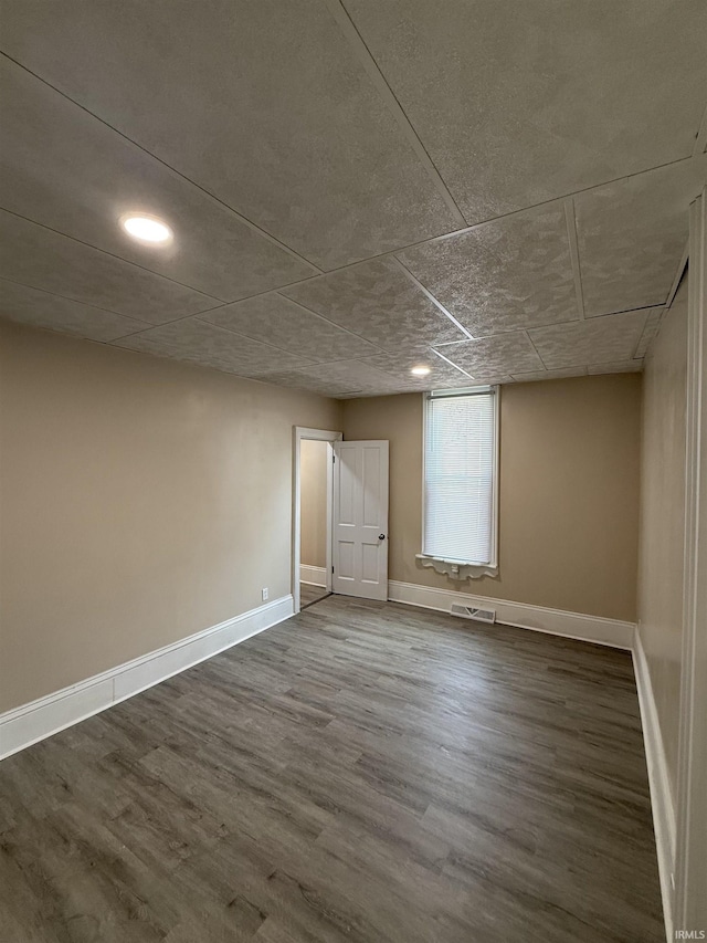 below grade area with recessed lighting, baseboards, visible vents, and dark wood finished floors