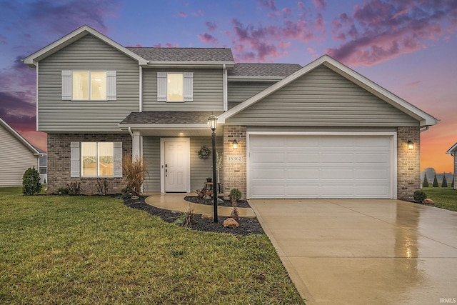 traditional home with a lawn, roof with shingles, brick siding, an attached garage, and driveway