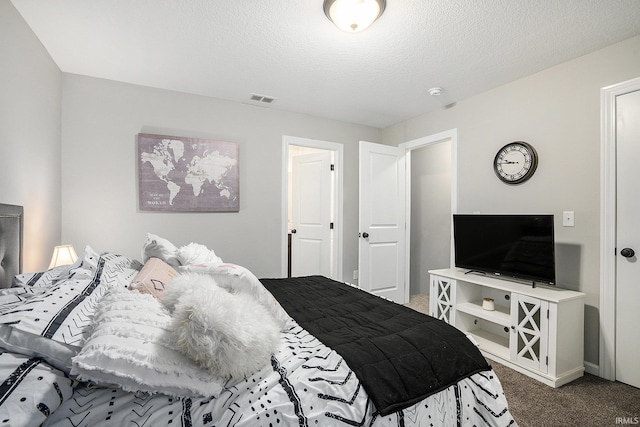 carpeted bedroom with a textured ceiling, baseboards, and visible vents