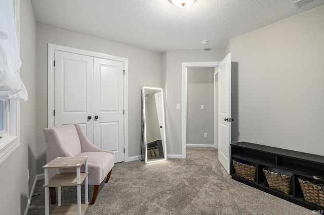 living area with carpet floors, a textured ceiling, visible vents, and baseboards